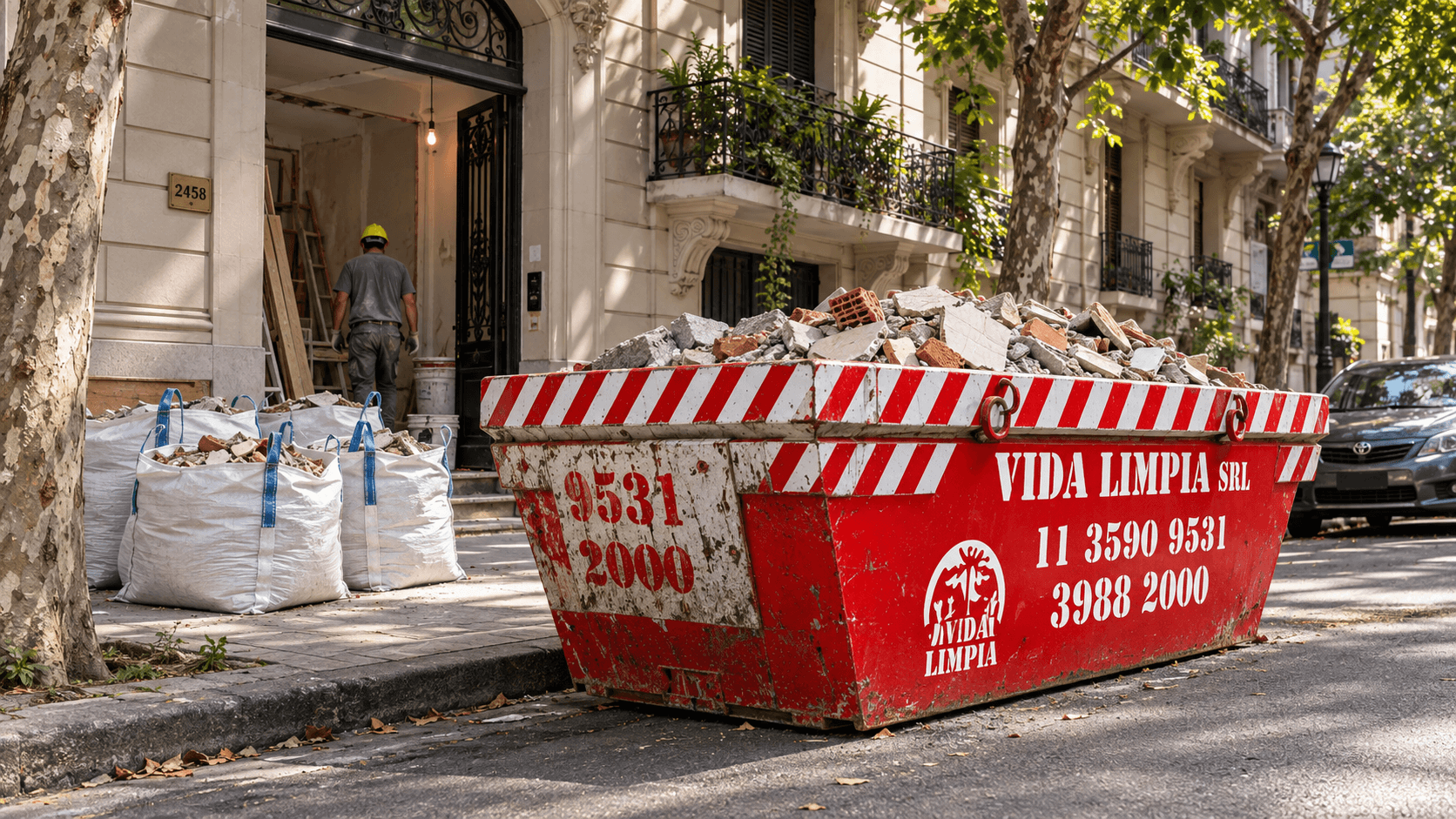 Volquete cargado con escombros junto a bolsas de escombro en la vereda de una obra en CABA
