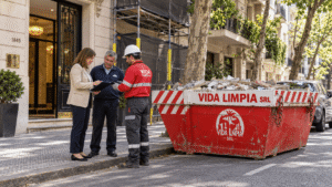 Volquete ubicado sobre la calzada frente a un edificio de departamentos en CABA durante una obra en espacios comunes